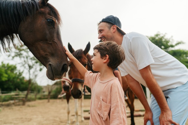 Family members interacting with horses at a ranch
